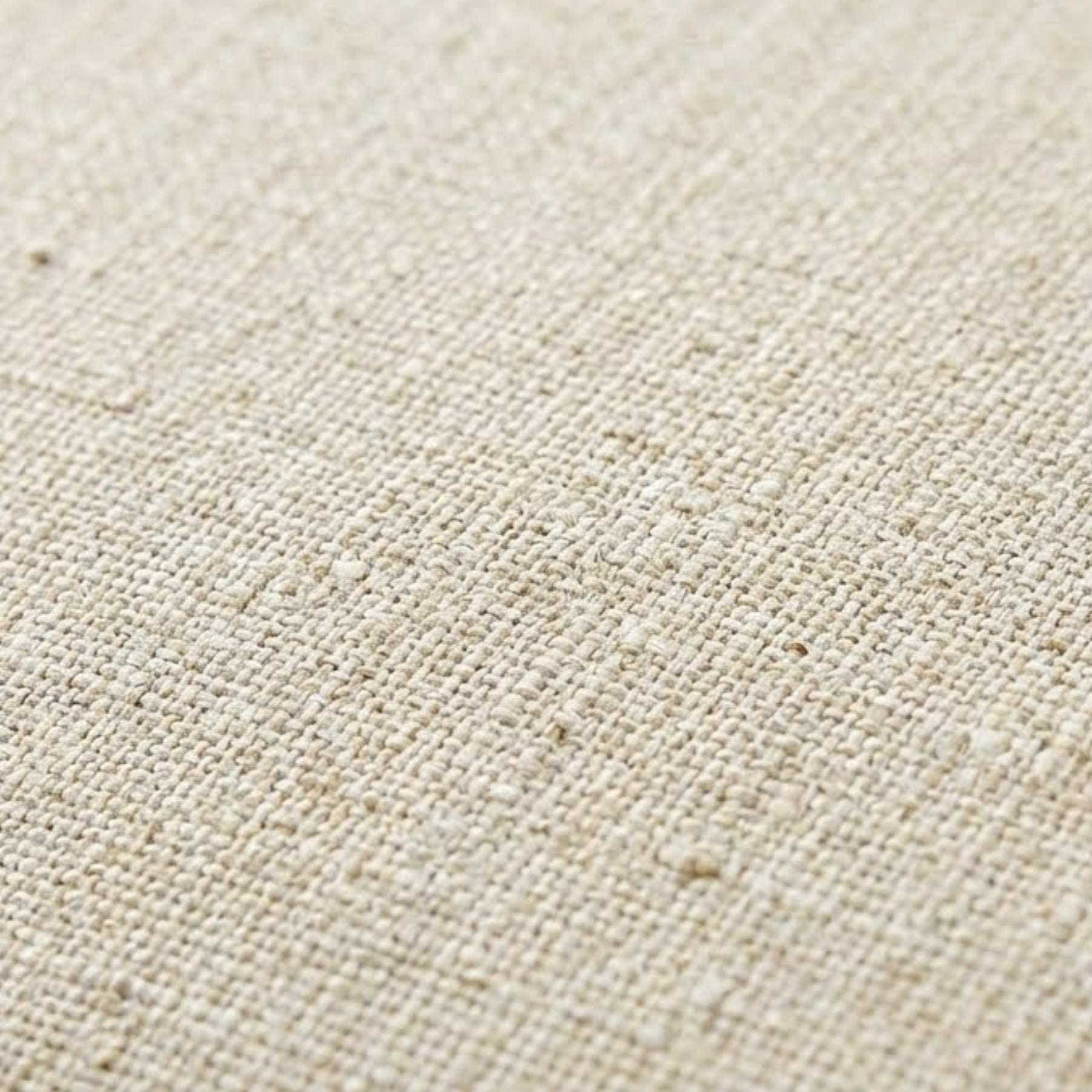 Macro close-up of the oatmeal linen upholstery texture on the swivel accent chair.