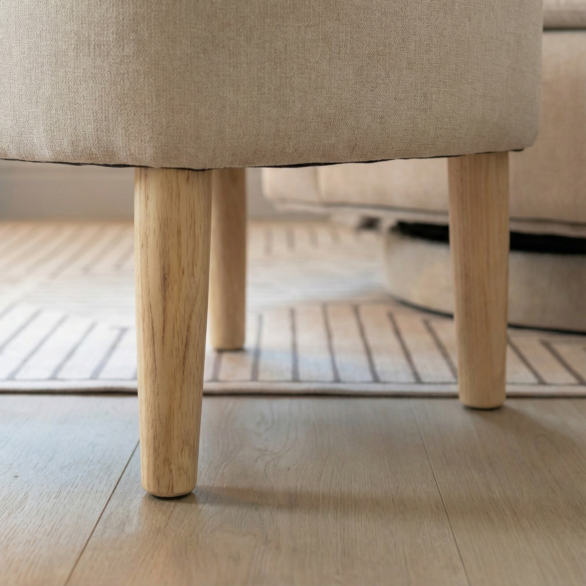 Close-up of the chair legs and base detail on the swivel accent chair with ottoman.