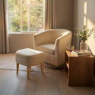 Swivel accent chair with ottoman in oatmeal linen set beside a window for a cozy living room corner.