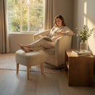 Model lounging on the swivel accent chair with ottoman, showing everyday comfort in a compact room.