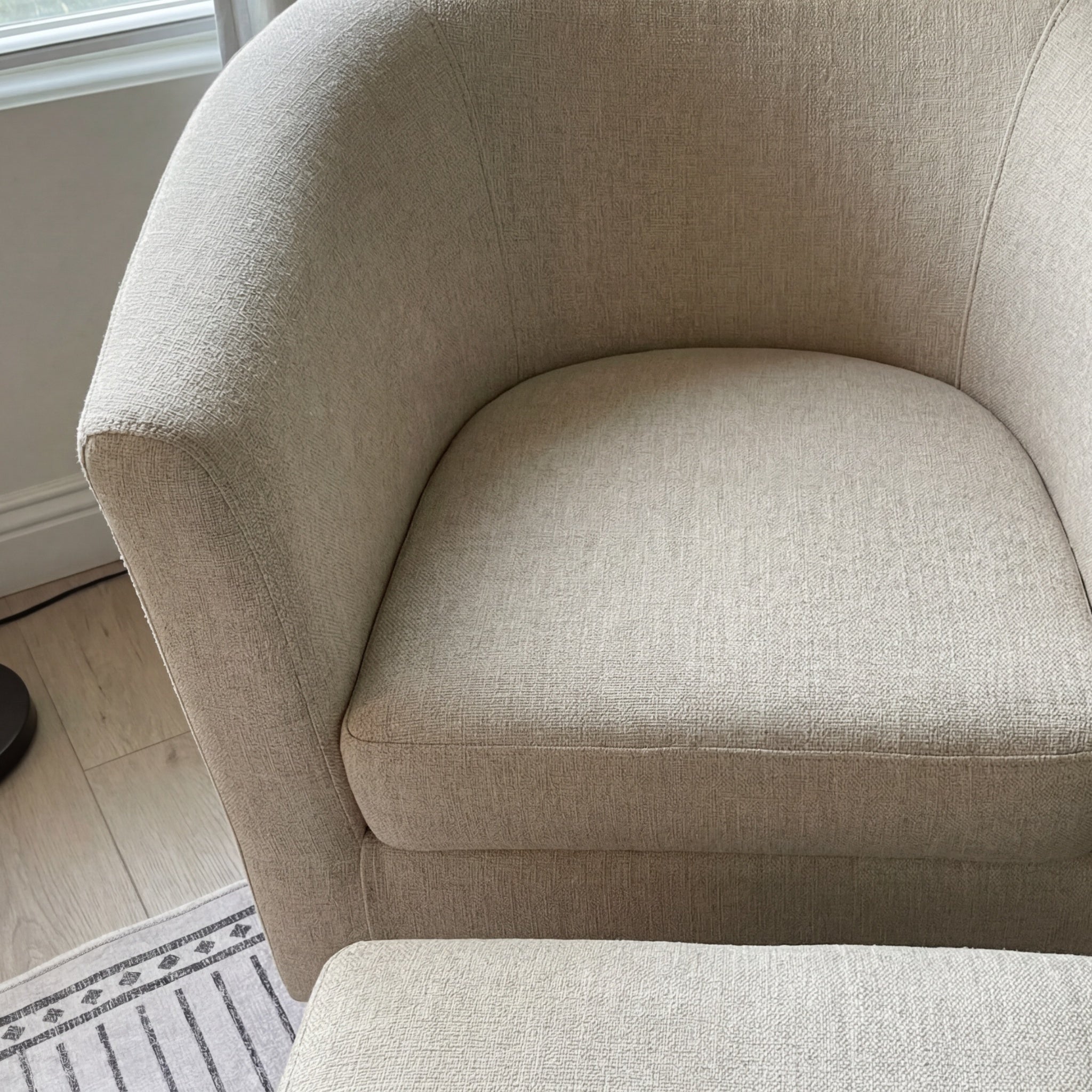 Mid-shot of the swivel accent chair with ottoman highlighting the curved back and roomy seat.
