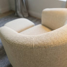 Side angle of the swivel accent chair with ottoman showing the rounded silhouette and compact footprint.