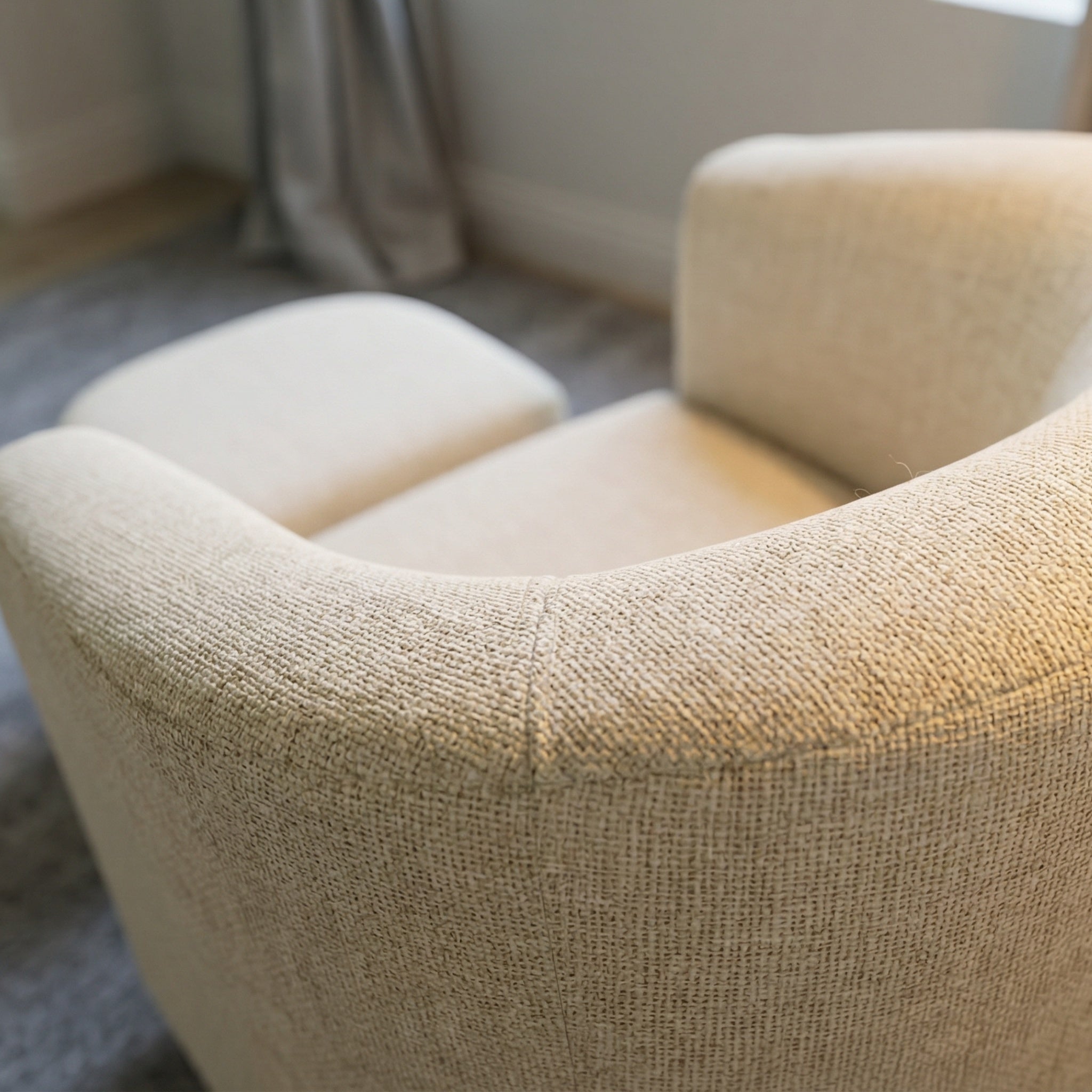 Side angle of the swivel accent chair with ottoman showing the rounded silhouette and compact footprint.